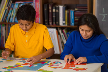 Hispanic Child Completing Puzzle with Mom