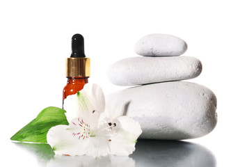 Obraz na płótnie Canvas Spa stones with aromatic oils and flower isolated on white