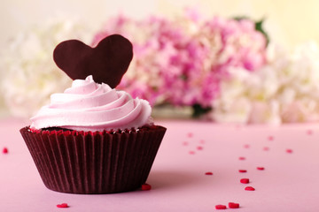 Delicious Valentine Day cupcake on light background