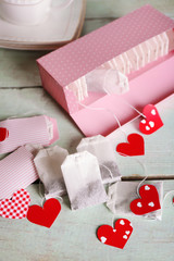 Heart shaped teabag tags and box on wooden background