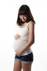 Asian pregnant woman looking and touching her belly