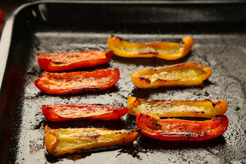 Composition with roasted sliced pepper on pan, close-up