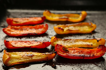 Composition with roasted sliced pepper on pan, close-up
