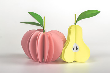 isolated paper fruits - pink apple and half yellow pear