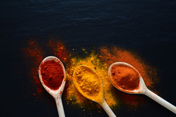 Colorful spices on cooking spoons