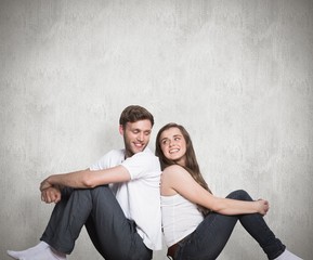 Composite image of young couple sitting on floor