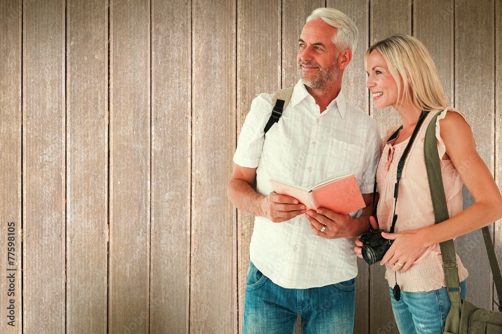 Poster composite image of happy tourist couple using the guidebook