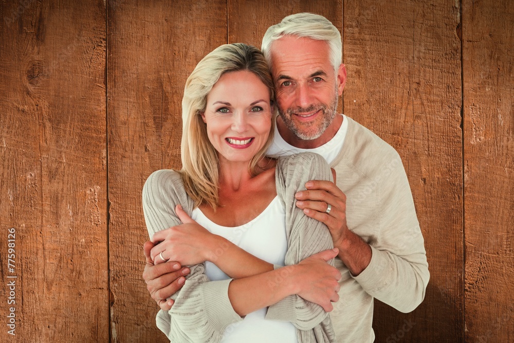 Poster Composite image of happy couple standing and hugging