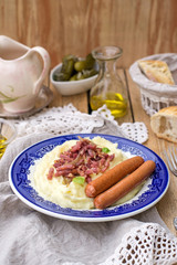 Mashed potatoes with apples served with sausages and bacon