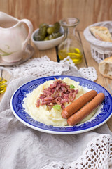 Mashed potatoes with apples served with sausages and bacon