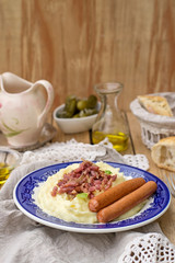 Mashed potatoes with apples served with sausages and bacon