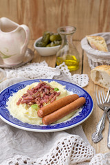 Mashed potatoes with apples served with sausages and bacon