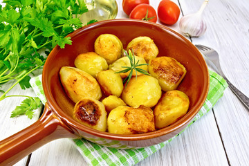 Potatoes fried in ceramic pan on light board
