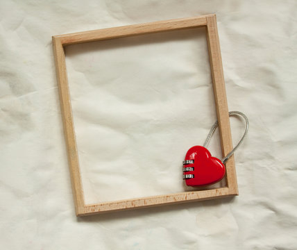 wooden frame and red metal lock on paper background