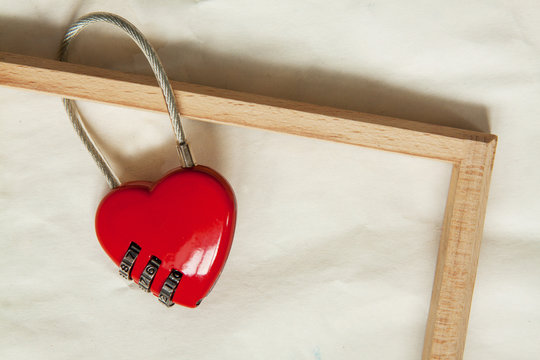 wooden frame and red metal lock on paper background