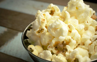 Cropped Popcorn in a silver bowl over wood background