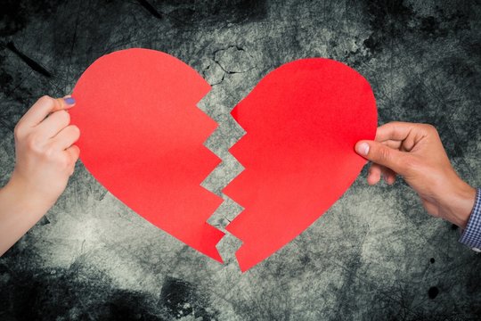 Composite image of two hands holding broken heart
