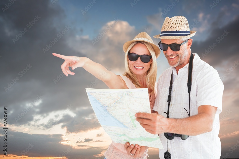 Aufkleber Composite image of happy tourist couple using map and pointing
