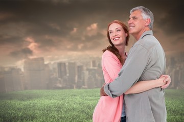 Obraz premium Composite image of casual couple hugging and smiling