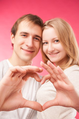 Obraz na płótnie Canvas Couple making shape of heart by their hands