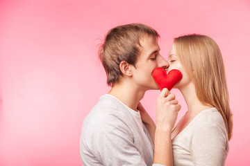 Couple kissing hiding behind little red heart
