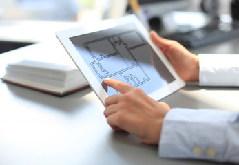 Real-estate agent showing house plans on electronic tablet