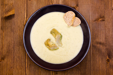 Cream of artichoke on wooden table top view