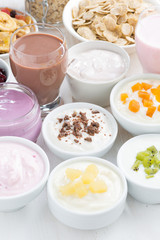 Assorted fresh fruit yoghurts and breakfast ingredients