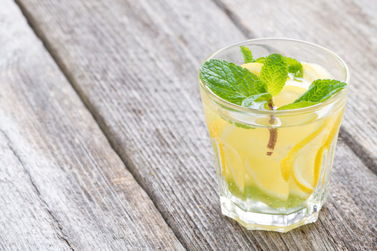 refreshing mint lemonade in glass on a wooden background