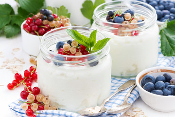 yogurt with fresh berries and breakfast foods on table, close-up