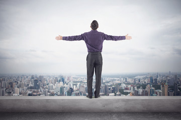 Confident businessman purple shirt and trausers standing on edge