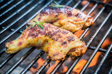 Roasted chicken legs on the grill with fire