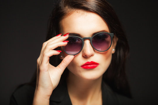 Glamour woman with sunglasses, red lips and nails