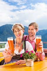 Paar auf Berghütte trinkt Weißbier