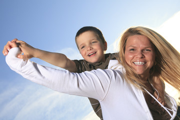 A portrait of a boy with is mother outside