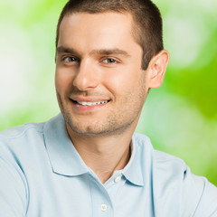 Portrait of young happy smiling attractive man, outdoors