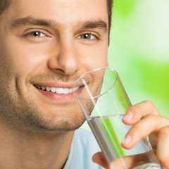 Cheerful man drinking water, outdoor