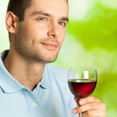 Handsome man with glass of redwine, outdoor