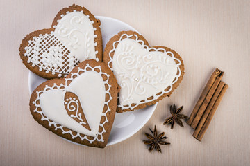 White heart shape gingerbread cookies on  plate with cinnamon