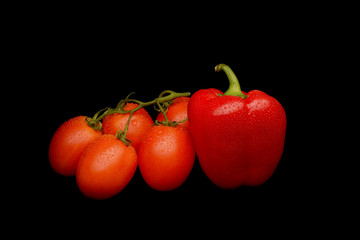Tomatoes and sweet pepper on black background