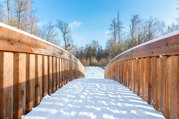 Snow landscape with wooden bridge in forest area