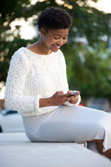 Fototapeta premium African american woman sending text message with cellphone
