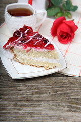 Cup of tea, piece of cake and red rose