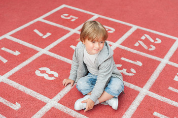 Adorable little boy resting on a schoolyard