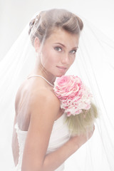 Beautiful smiling bride in the veil with bouquet