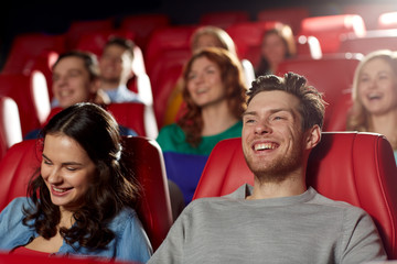 happy friends watching movie in theater