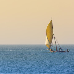 Wooden sailboat (dhow) on the clear turquoise water of Zanzibar