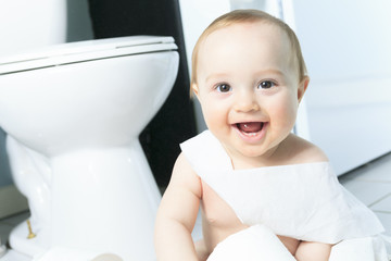 Toddler ripping up toilet paper in bathroom