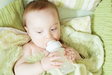 Funny little baby with beautiful standing in a round white crib