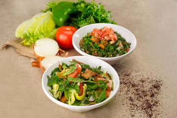 Plates of traditional Arabic salad fattouch and tabbouleh